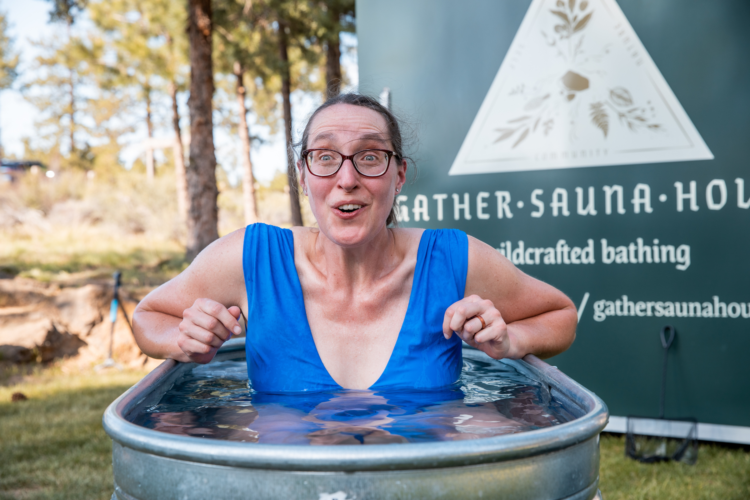 AdventurUs Woman in blue bathing suit entering cold plunge after sauna